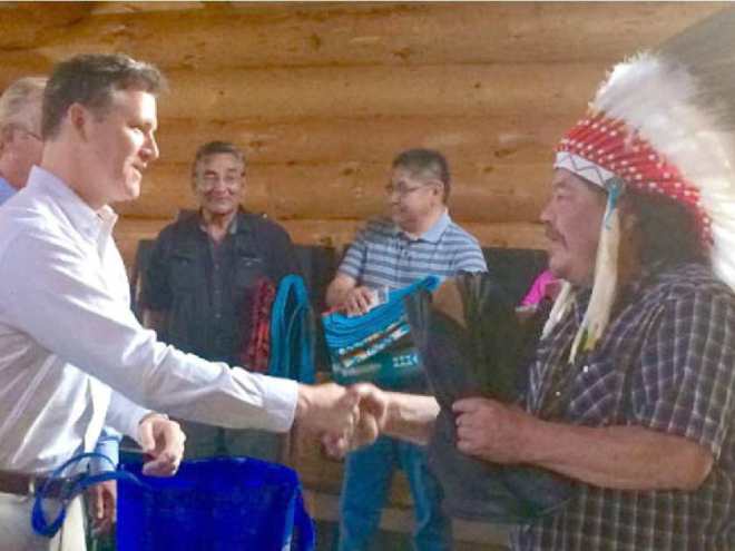 Grand Chief Warren White and Energy East Pipeline President François Poirier shake hands during a traditional ceremony in the sacred roundhouse of the Wauzhushk Onigum community, near Kenora, Ont.